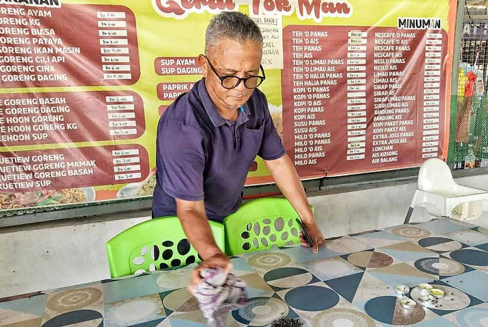 Kamarul Zaman shows the flies after using a lemongrass fly spray.