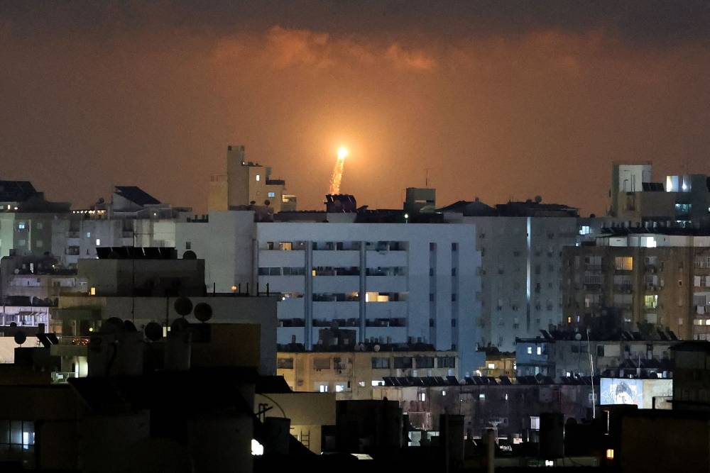 Rocket trails are seen in the sky above the Israeli coastal city of Netanya amid a fresh barrage of Iranian missile attacks on June 17, 2025. (Photo by JACK GUEZ / AFP)