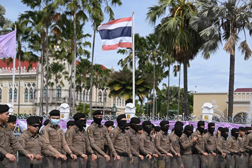 Thai police stand outside the Government House in Bangkok on June 19, 2025, in anticipation of Thai royalists protesting to call for the government's resignation. (Photo by Lillian SUWANRUMPHA / AFP)