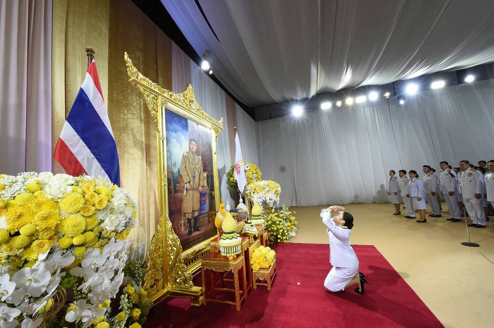 This handout picture released and taken by the Royal Thai Government on August 18, 2024 shows Paetongtarn Shinawatra, known by her nickname "Ung Ing" and daughter of former prime minister Thaksin Shinawatra, paying respects to an image of Thai king Maha Vajiralongkorn during the royal endorsement ceremony appointing her as Thailand’s new prime minister in Bangkok. Thai Prime Minister Paetongtarn Shinawatra faced mounting calls to resign on June 19, 2025 after a leaked phone call she had with former Cambodian leader Hun Sen provoked widespread anger and a key coalition partner to quit. (Photo by Handout / ROYAL THAI GOVERNMENT / AFP) 