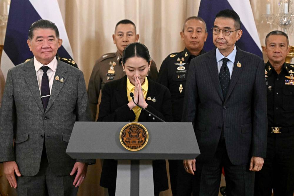 Thailand's Prime Minister Paetongtarn Shinawatra (C) gestures at a press conference next to Deputy Prime Minister and Defence Minister Phumtham Wechayachai (L), Foreign Minister Maris Sangiampongsa (2nd R), Armed Forces Commander Pana Klaewplodthuk (3rd R), Chief of the Defence Forces Songwit Noonpackdee (R), and Commissioner-General of the Royal Thai Police Kitrat Phanphet (centre L) at Government House in Bangkok on June 19, 2025. Thai Prime Minister Paetongtarn Shinawatra on June 19 apologised for her leaked phone call with Cambodia's ex-leader, which prompted a political crisis that threatens to collapse her government. (Photo by Lillian SUWANRUMPHA / AFP)