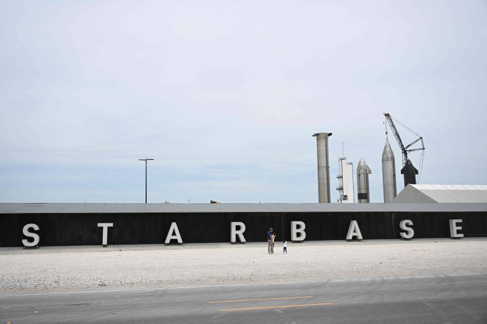 (FILES) People take pictures of the rocket garden ahead of the SpaceX Starship flight test from Starbase in Boca Chica, Texas on April 16, 2023. - (Photo by Patrick T. Fallon / AFP)