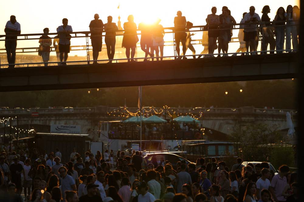 Music enthusiasts gather for free concerts on the banks of the Seine river during France's annual street music festival, the Fete de la Musique, in Paris on June 21, 2025. (Photo by ROMAIN PERROCHEAU / AFP)