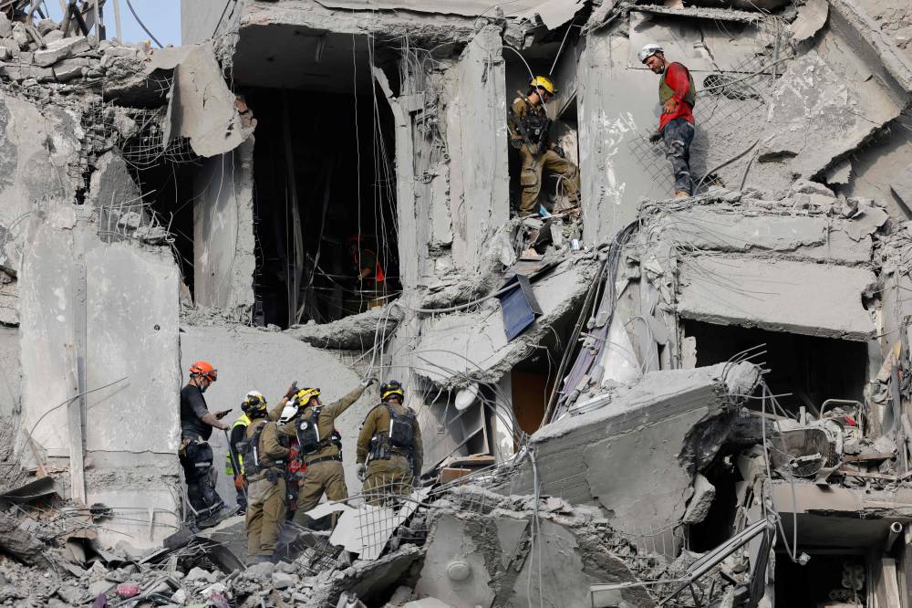 Emergency workers check the damage caused to a building from an Iranian missile strike in Beersheba in southern Israel on June 24, 2025. - (Photo by John Wessels / AFP)