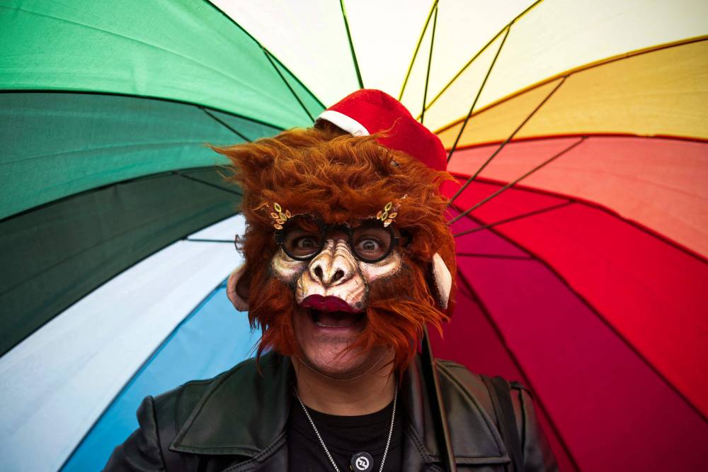A man wearing a mask takes part in the formation of the world's biggest LGBT pride flag at Zocalo Square in Mexico City, Mexico, on June 22, 2025. (Photo by Rodrigo Oropeza / AFP)