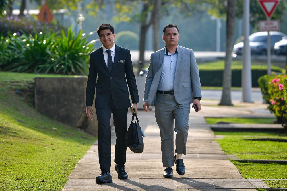 Upon hearing the verdict, Syed Saddiq, dressed in a black suit, covered his face with his hands in apparent relief after being freed from the sentence. - Bernama photo