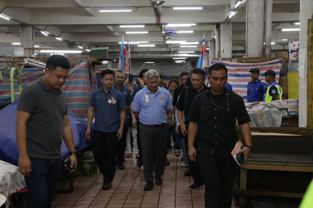 Sabin (centre) inspecting the conditions at Kota Kinabalu Market after launching the Rat Extermination Campaign. (Photo by Asyikin Asmin)