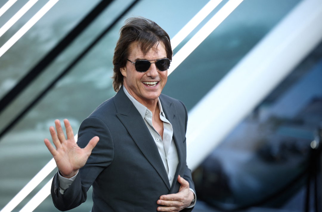 US actor Tom Cruise gestures upon arrival for the European Premier of F1 The Movie, at Cineworld Leicester Square, central London, on June 23, 2025. (Photo by HENRY NICHOLLS / AFP)