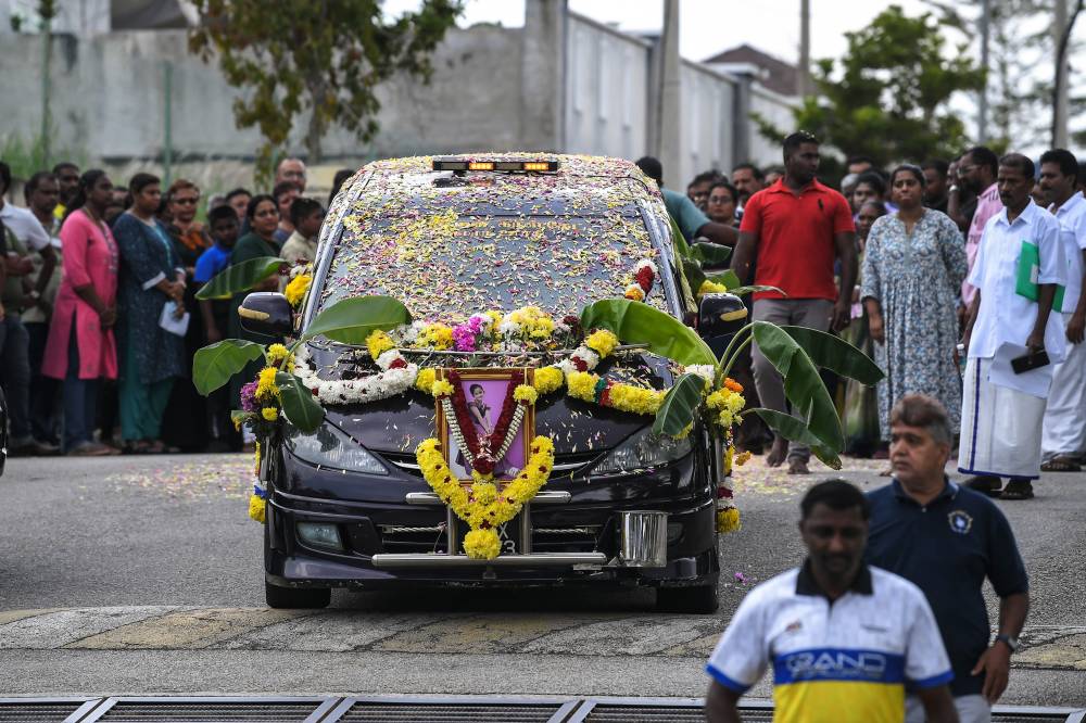 The vehicle carrying the body of the boat capsize victim, the late V. Vennpani, leaves the residential area after a religious ceremony held as part of her final rites at her home in Sungai Petani Heights, today. - Photo by Bernama