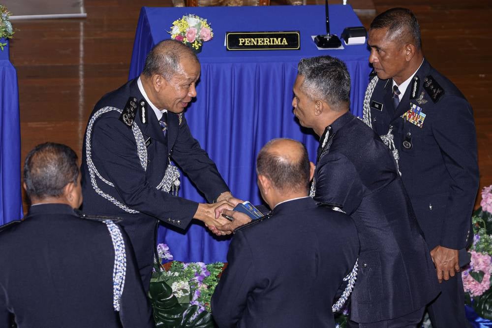 IGP Datuk Seri Mohd Khalid Ismail shakes hands with former Bukit Aman CID director Datuk Seri Mohd Shuhaily Mohd Zain (second from right) during the handover ceremony for the position of director and chairman of the Royal Malaysia Police Family Association (PERKEP) Malaysia, CID Division, at the Bukit Aman Police Headquarters today. Also present was the newly appointed Bukit Aman acting CID director of Datuk Fadil Marsus (right). - Photo by Bernama
