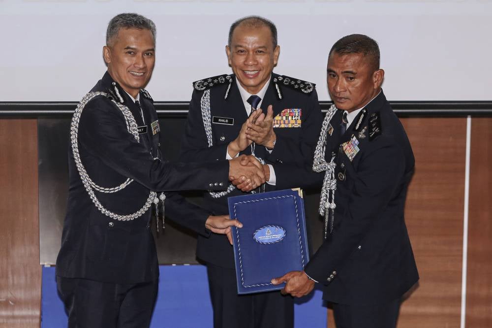 IGP Datuk Seri Mohd Khalid Ismail witnesses the symbolic handover of duties between Datuk Seri Mohd Shuhaily Mohd Zain (left) and Datuk Fadil Marsus (right) during the handover ceremony for the position of director and chairman of the Royal Malaysia Police Family Association (PERKEP) Malaysia, CID Division, at the Bukit Aman Police Headquarters today. - Photo by Bernama