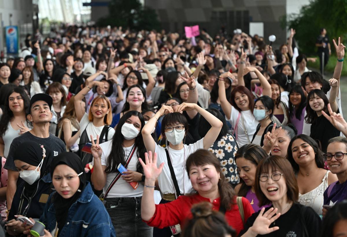 Fans of K-pop boy band BTS pose for photos as they queue up for the annual 'BTS Festa' celebrating the group's debut anniversary at KINTEX exhibition centre in Goyang on June 13, 2025. Photo by Jung Yeon-je/AFP