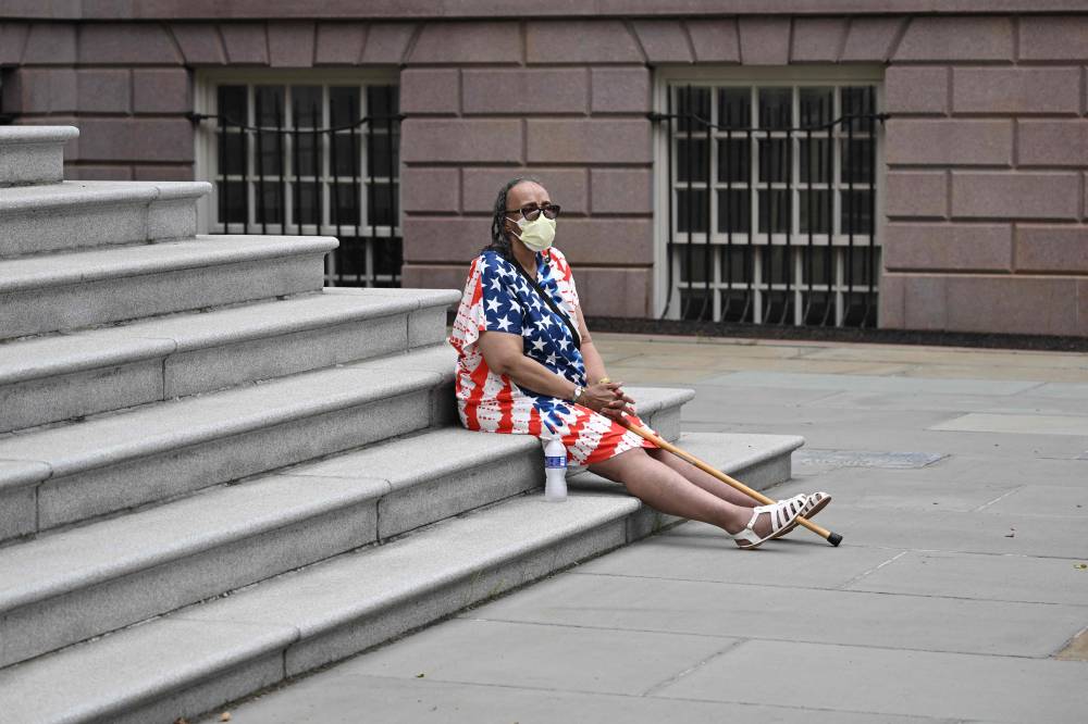 A supporter of New York City Mayor Eric Adams sits outside City Hall as Adams speaks about his re-election campaign in New York City on June 26, 2025. (Photo by ANGELA WEISS / AFP)