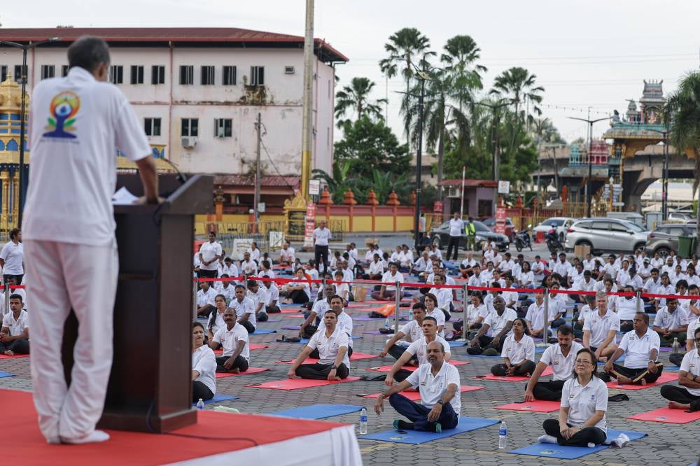 Secretary-General of the Ministry of Youth and Sports, Datuk Dr Nagulendran Kangayatkarasu, listens to the speech by Indian High Commissioner to Malaysia, B.N. Reddy, during the 11th International Day of Yoga 2025 programme held in the vicinity of the Batu Caves Temple. - Bernama photo