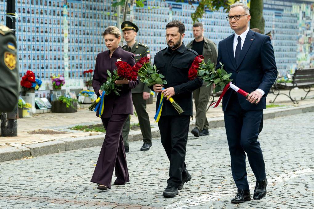 This handout picture taken and released by Ukrainian presidential press-service on June 28, 2025 shows Ukraine's President Volodymyr Zelensky (C), his wife Olena Zelenska (L) and Poland's President Andrzej Duda walking to lay flowers to the Memorial Wall of Fallen Defenders of Ukraine in the Russian-Ukrainian War outside Saint Michael's Golden-domes Cathedral in Kyiv. (Photo by Handout / Ukrainian Presidential Press-Service / AFP)