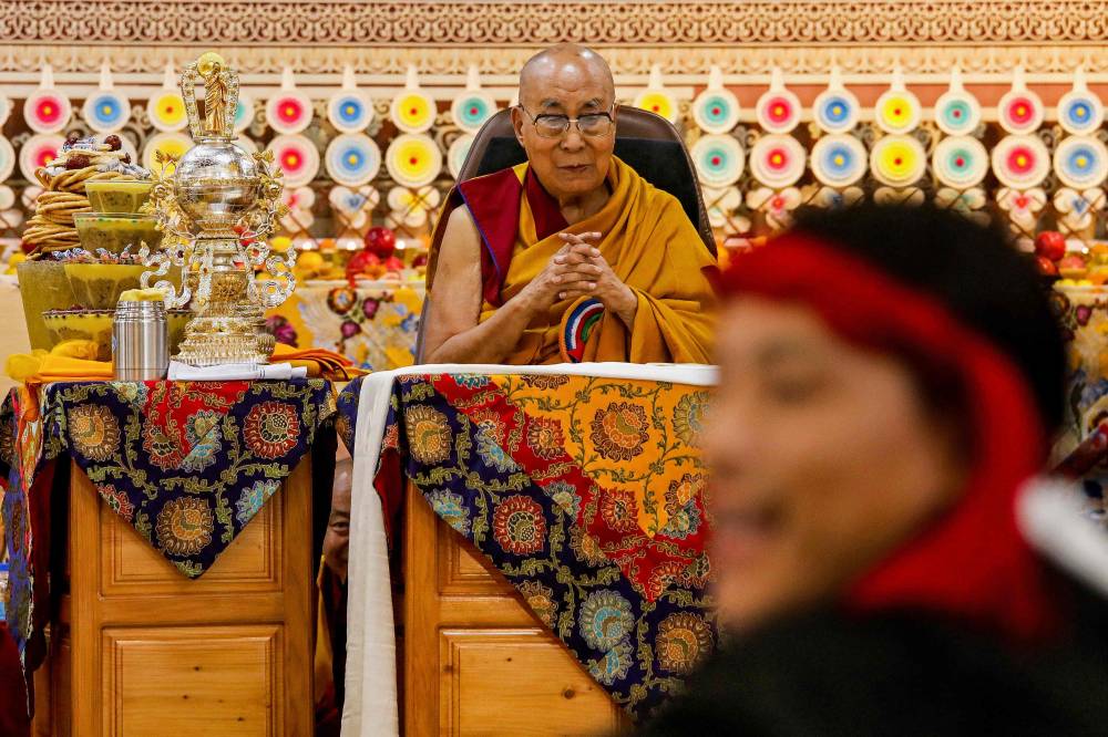 Tibetan spiritual leader the Dalai Lama looks on as offerings presented by Buddhist followers are laid on a table during a Long Life Prayer offering ceremony at the Main Tibetan Temple in McLeod Ganj, near Dharamsala on June 30, 2025. Exiled Tibetan spiritual leader, the Dalai Lama, gave on June 30, the strongest indication yet that the 600-year-old institution would continue after his death, at prayer celebrations for his 90th birthday. The leader, who turns 90 on July 6, is according to Tibetans the 14th reincarnation of the Dalai Lama. (Photo by Sanjay BAID / AFP)