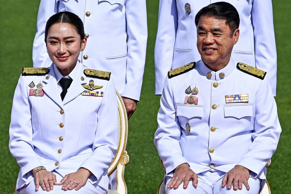 This photo taken on September 7, 2024 shows Thailand's Prime Minister Paetongtarn Shinawatra (L) and Deputy Prime Minister of Thailand and Minister of Transport Suriya Jungrungreangkit posing for a group photo with members of the cabinet at Government House in Bangkok. Thai Prime Minister Paetongtarn Shinawatra was suspended by the country's Constitutional Court on July 1, 2025, while her father went on trial for royal defamation in the latest setbacks for the country's dominant political dynasty. While the Constitutional Court investigates whether she breached ministerial ethics during a diplomatic spat with Cambodia, Thai media reports said that deputy prime minister Suriya Jungrungreangkit, from her own Pheu Thai party, will initially take charge. (Photo by MANAN VATSYAYANA / AFP)