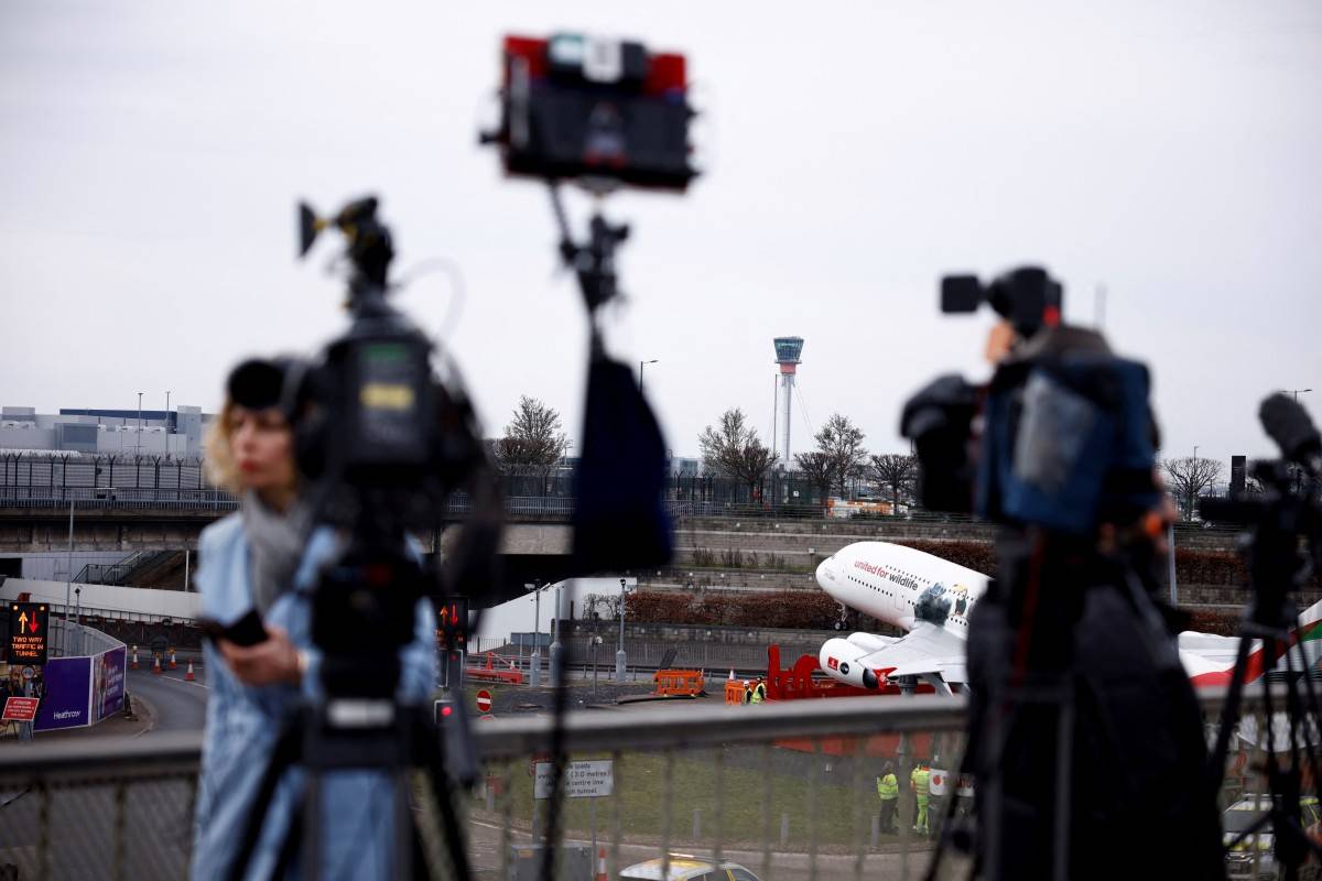 Journalists speak in front of cameras with following the closure of Heathrow airport after a fire broke out at a substation supplying power of the airport, in Hayes, west London, on March 21, 2025. - (Photo by BENJAMIN CREMEL / AFP)