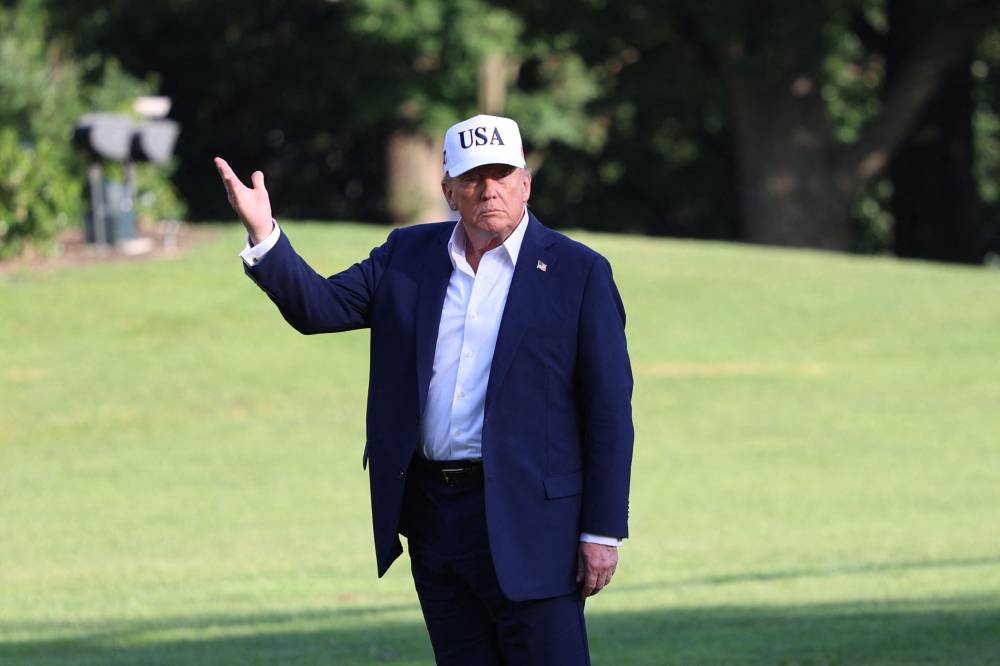 US President Donald Trump stops to gesture at the US flag as he walks on the South Lawn from Marine One to the White House in Washington, DC on July 6, 2025, after spending the weekend at his residence in Bedminster, New Jersey. - (Photo by ALEX WROBLEWSKI / AFP)