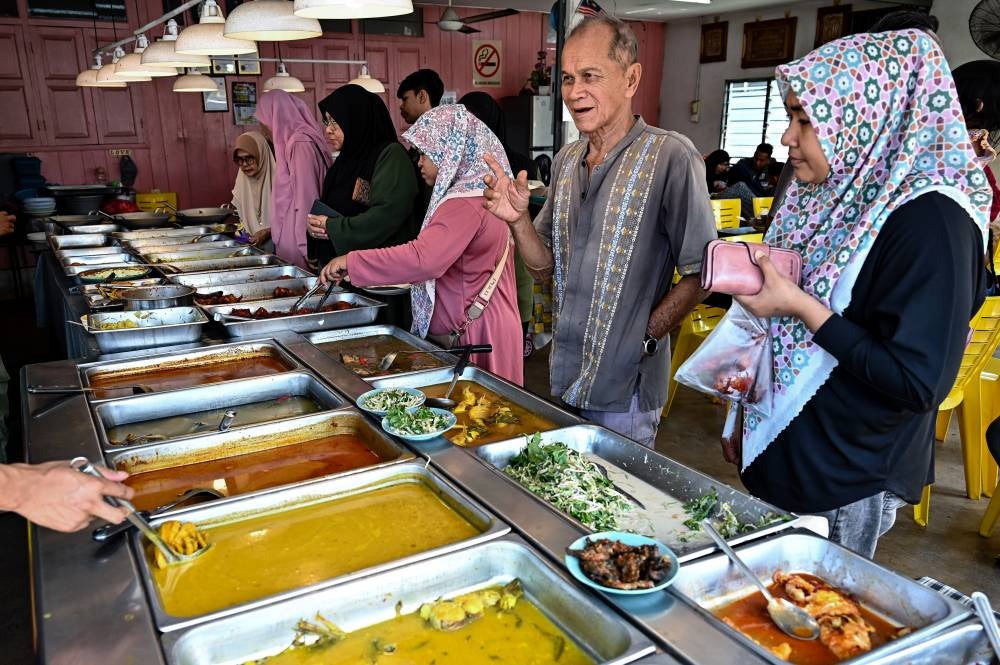 Members of the public seize the opportunity to buy dishes priced at RM5 per serving during a visit to Warung Juedin, Kampung Tok Jiring. - Bernama photo
