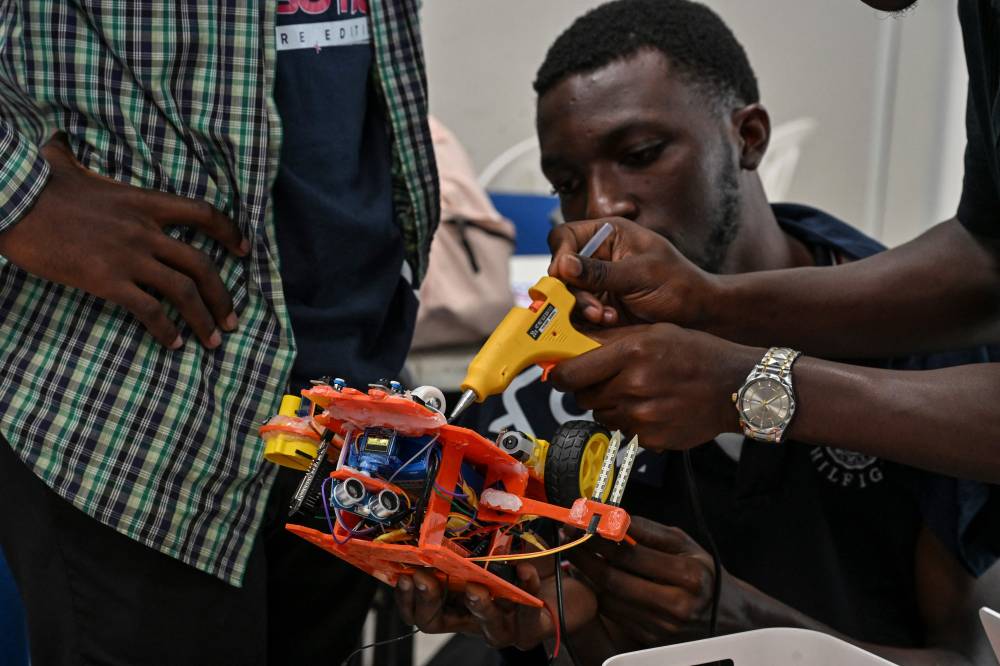 Young robotic enthusiasts take part in the first edition of the National Robotic Competition on July 3, 2025 in Abidjan. (Photo by Issouf SANOGO / AFP)