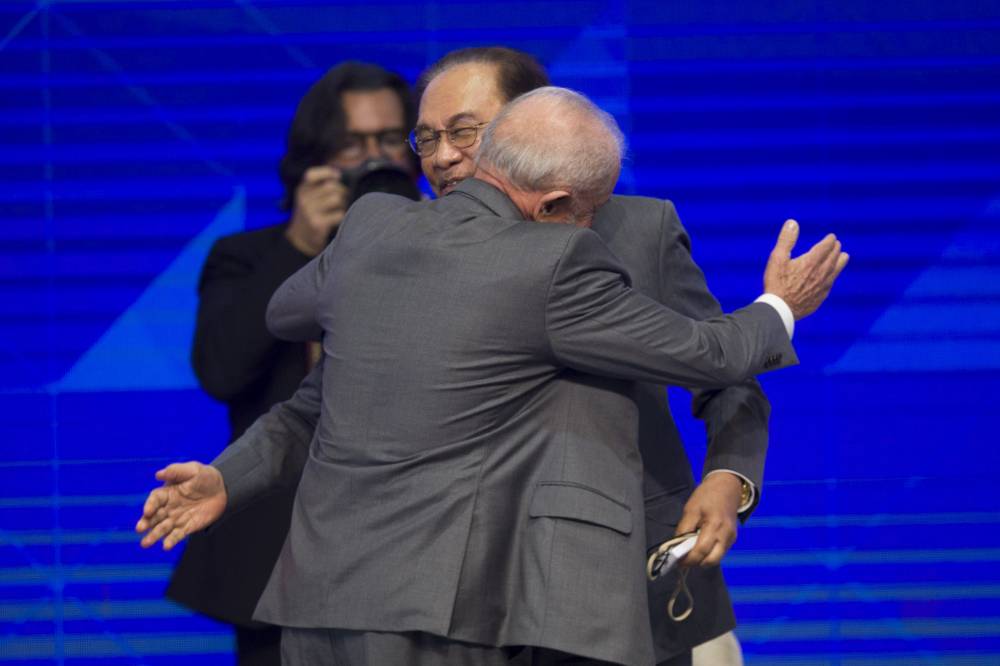 Malaysia's Prime Minister Datuk Seri Anwar Ibrahim (R) and Brazil's President Luiz Inacio Lula da Silva greet each other during the BRICS Business Forum in Rio de Janeiro, Brazil, on July 5, 2025. BRICS leaders meeting in Rio de Janeiro from Sunday are expected to decry Donald Trump's hardline trade policies, but are struggling to bridge divides over crises roiling the Middle East. (Photo by Daniel RAMALHO / AFP)