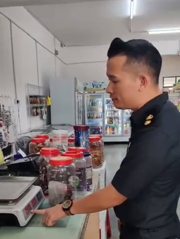 An enforcement officer inspects an expired electronic weighing scale that was still in use.