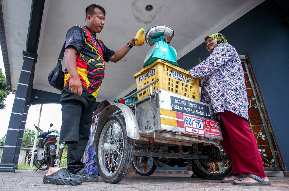 The seventh of ten siblings, he took the initiative to earn a living by selling fruits from his three-wheeled motorcycle around Bota, near Parit, stopping at popular eateries frequented by the public. - Bernama photo