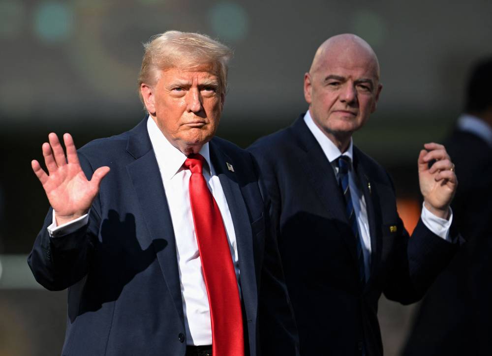 US President Donald Trump waves next to FIFA President Gianni Infantino during the award ceremony for the FIFA Club World Cup 2025 Champions, following the final football match between England's Chelsea and France's Paris Saint-Germain at the MetLife Stadium in East Rutherford, New Jersey on July 13, 2025. (Photo by ANGELA WEISS / AFP)