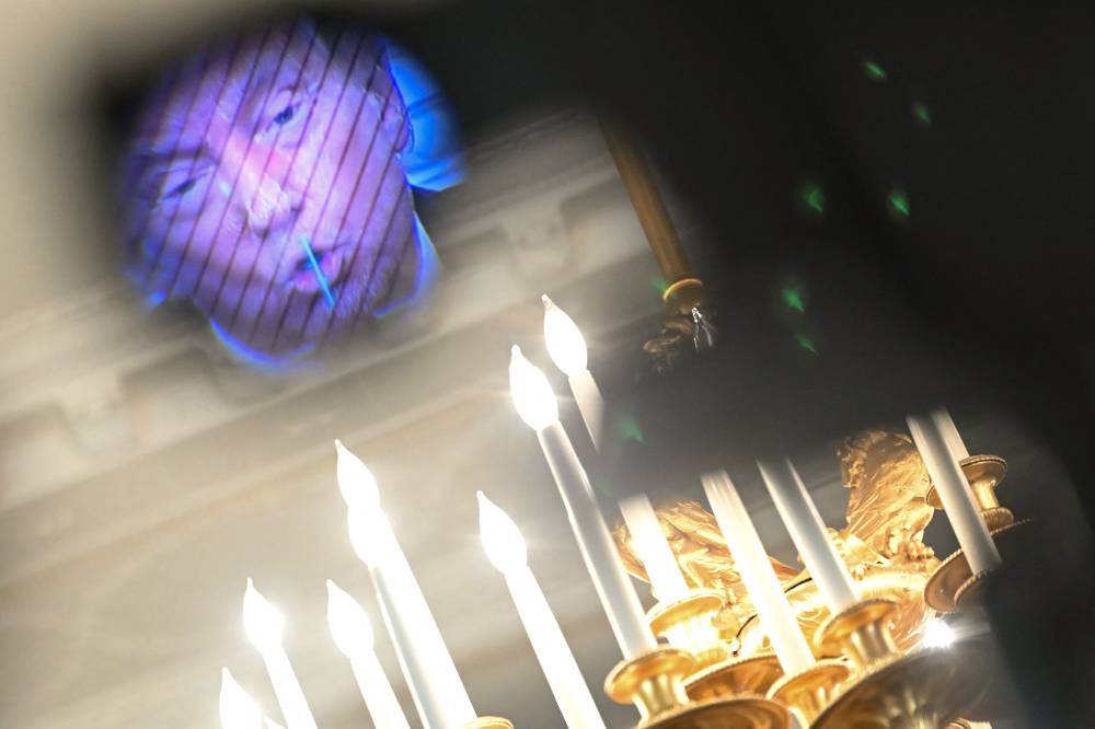 US President Donald Trump, seen through a viewfinder of a video camera, speaks during a White House Faith Office luncheon in the State Dining Room of the White House, in Washington, DC on July 14, 2025. (Photo by ANDREW CABALLERO-REYNOLDS / AFP)