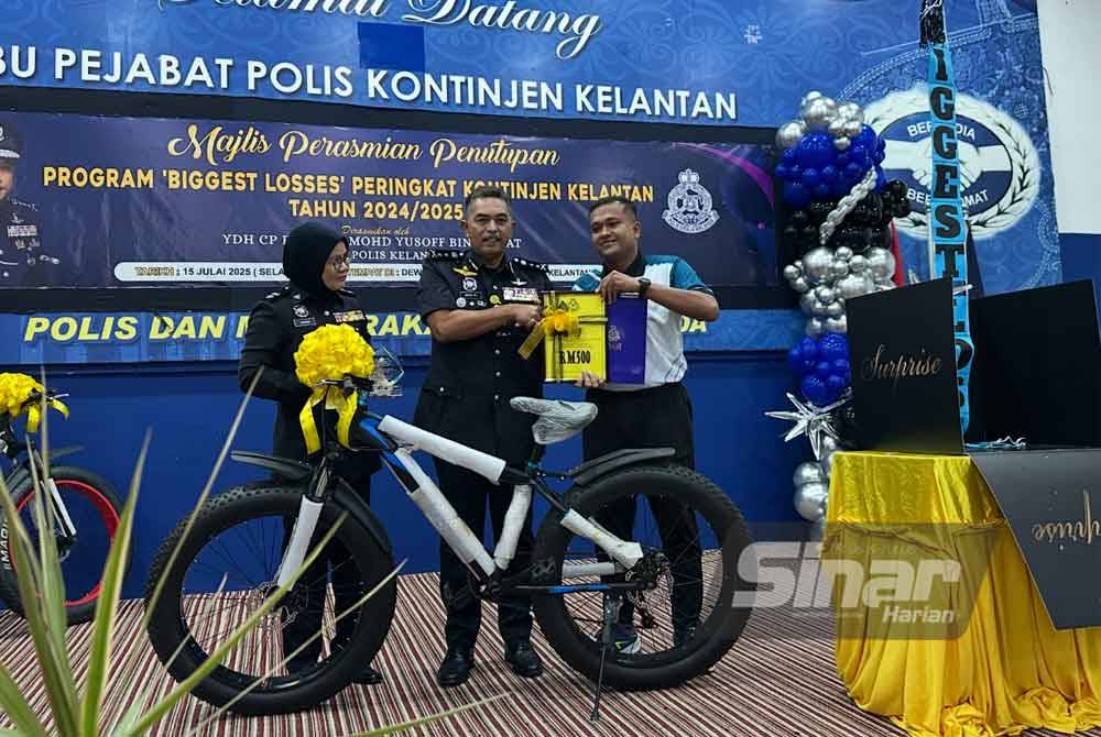 Aiman (right) also received a bicycle as a prize, presented by Mohd Ali (centre). - PHOTO: SINAR/ADILA SHARINNI WAHID 
