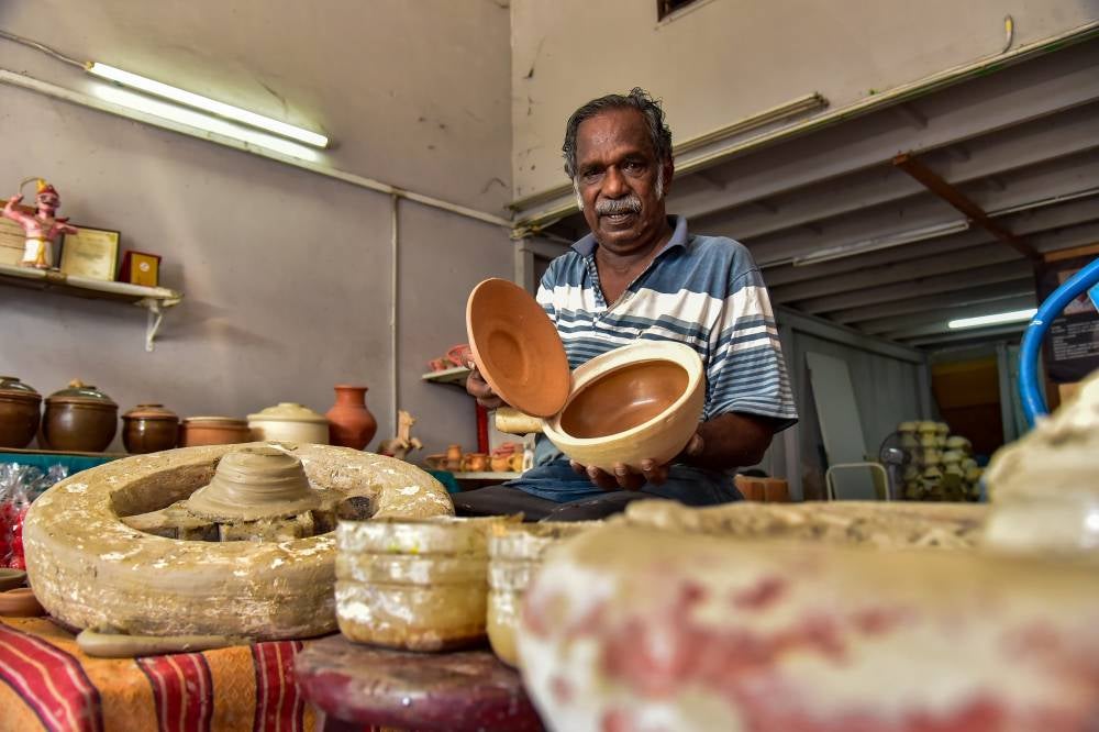 V. Ramadas remains dedicated to shaping clay using the ‘throwing wheel’ technique (a process of shaping clay) inherited from his father to make clay pots, rice cookers and water jars. Photo by Bernama
