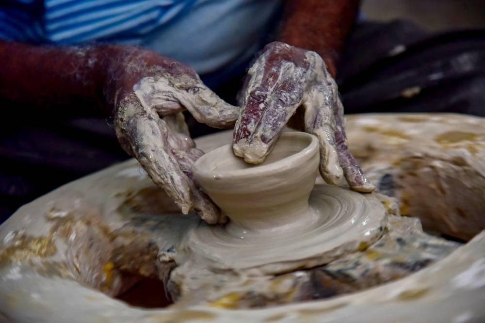 V. Ramadas remains dedicated to shaping clay using the ‘throwing wheel’ technique (a process of shaping clay) inherited from his father to make clay pots, rice cookers and water jars. Photo by Bernama