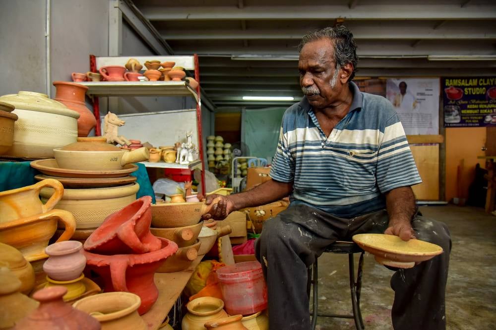V. Ramadas remains dedicated to shaping clay using the ‘throwing wheel’ technique (a process of shaping clay) inherited from his father to make clay pots, rice cookers and water jars. Photo by Bernama