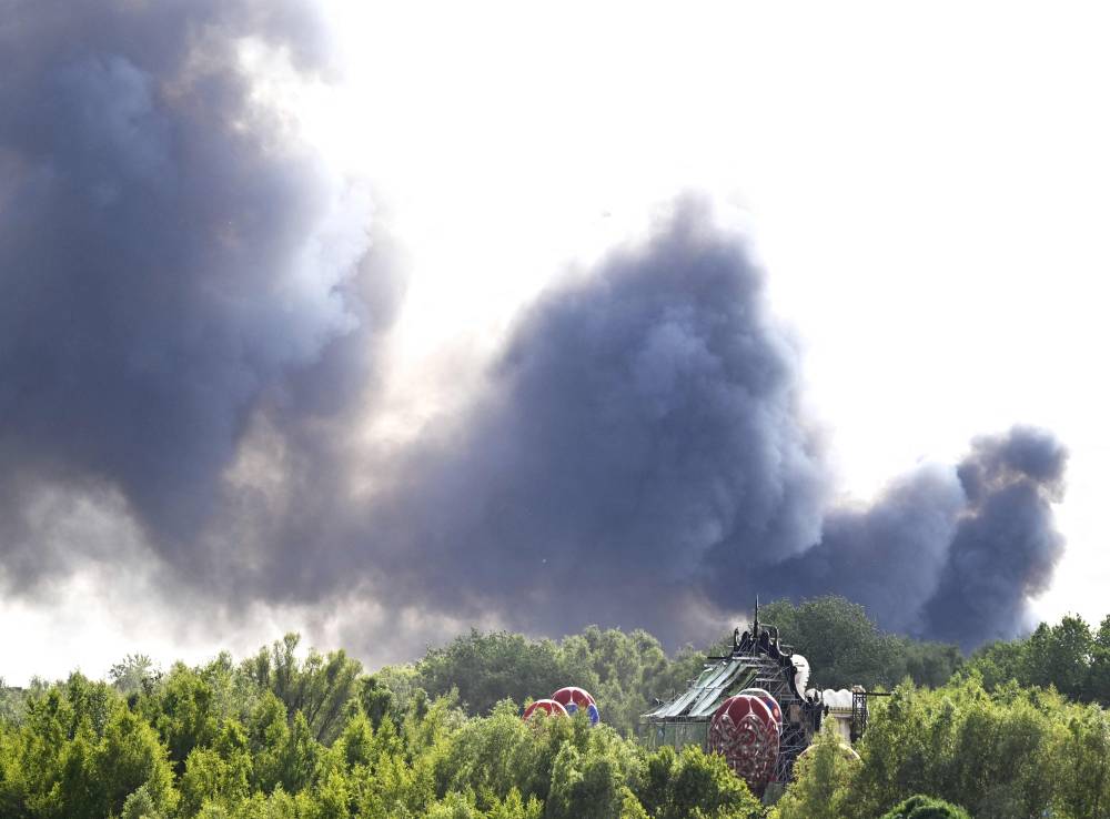 Smoke caused by a fire billows above the site of the Tomorrowland electronic music festival in Boom, northern Belgium on July 16, 2025. - (Photo by Tom Goyvaerts / Belga / AFP)