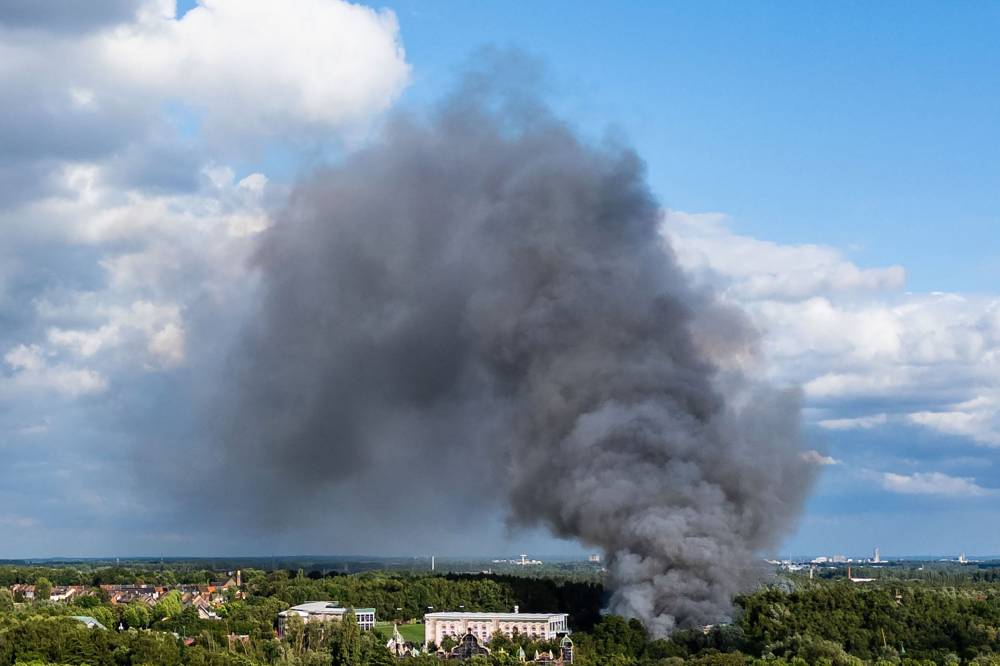 Smoke caused by a fire billows above the site of the Tomorrowland electronic music festival in Boom, northern Belgium on July 16, 2025. - (Photo by Tom Goyvaerts / Belga / AFP)