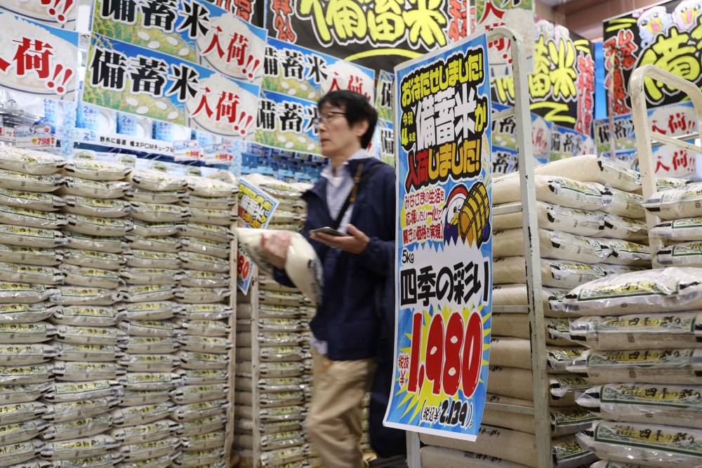 A customer walks past sacks of rice, released by the government from its reserve under a discretionary contract, at a branch of Japanese discount retailer Don Quijote in Tokyo on June 1, 2025. (Photo by JIJI PRESS / AFP)