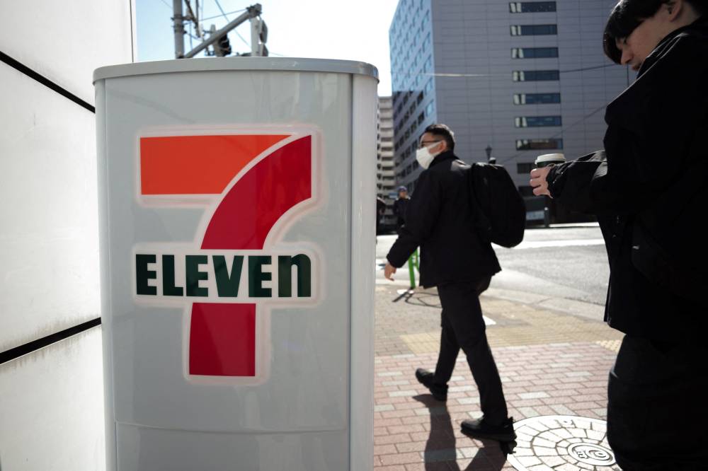 (FILES) This file photo taken on February 27, 2025 shows people walking past a 7-Eleven convenience store in central Tokyo. Shares in the Japanese owner of 7-Eleven were down 9.45 percent on the Tokyo Stock Exchange on July 17, 2025 after Canadian rival dropped its almost 50-billion USD takeover bid. (Photo by Kazuhiro NOGI / AFP)