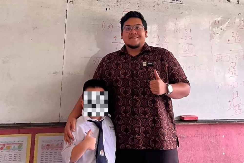 Teacher Muhammad Farid Ammar with the pupil from the viral video.