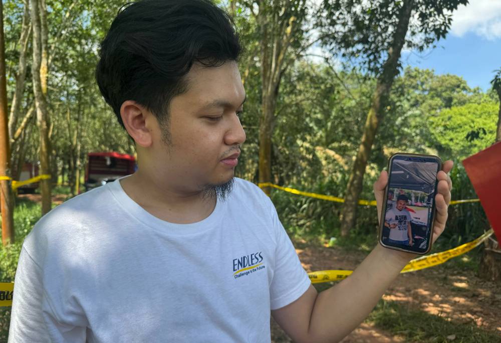 A friend of the missing man, Muhammad Syahmi Mansur, shows a photo of the 'victim' on his mobile phone. Bernama FILE PIX