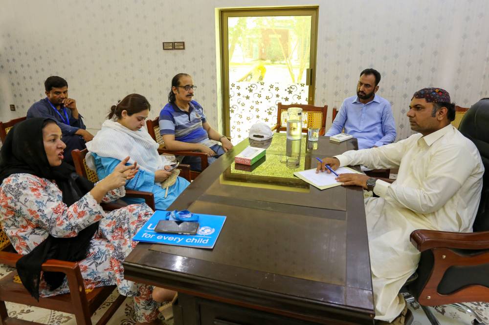 In this photograph taken on May 15, 2025, UNICEF Child Protection Officer Zahida Manzoor (L) speaks with Muhammad Azhar (R) Assistant Director of Municipal Committee in Rajanpur district in southwestern Punjab province. Ahmed Raza is invisible in the eyes of his government, unable to study or work because, like millions of other Pakistanis, he lacks identification papers. In the South Asian nation of more than 240 million people, parents generally wait until a child begins school at the age of five to obtain a birth certificate, which is required for enrolment in most parts of Pakistan. (Photo by Shahid Saeed MIRZA / AFP) / To go with 'Pakistan-Children-Social-Census', REPORTAGE