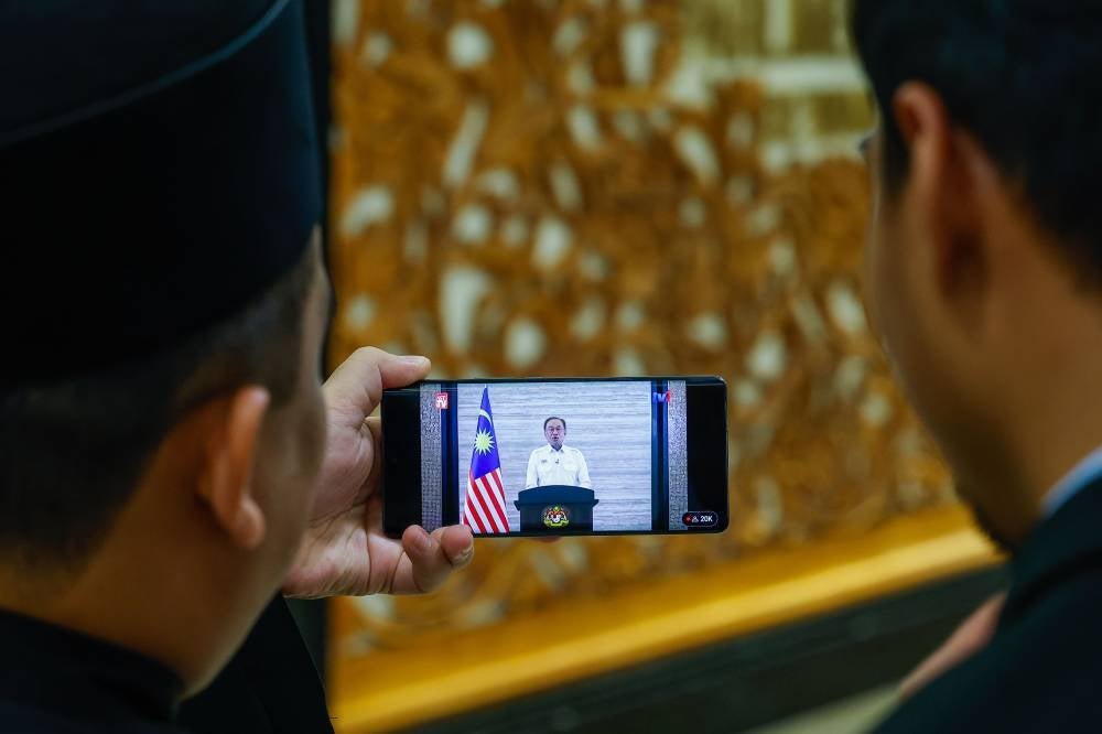 Several government staff were seen watching the live broadcast of Prime Minister Datuk Seri Anwar Ibrahim’s special announcement in appreciation of the Malaysian people, via the official website at the Parliament building today. Photo by Bernama