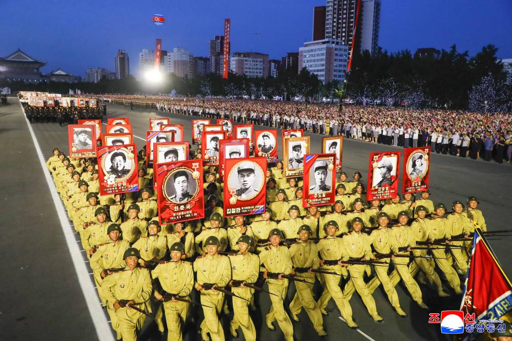 This picture taken on July 27, 2025 and released from North Korea's official Korean Central News Agency (KCNA) via KNS on July 28, 2025 shows a marchpast as people take part in celebrations to mark the 72nd anniversary of the end of the Korean War at the Pyongyang Gymnasium Square in Pyongyang. North and South Korea technically remain at war because the 1950-53 Korean War ended in an armistice, not a peace treaty. (Photo by KCNA VIA KNS / AFP)