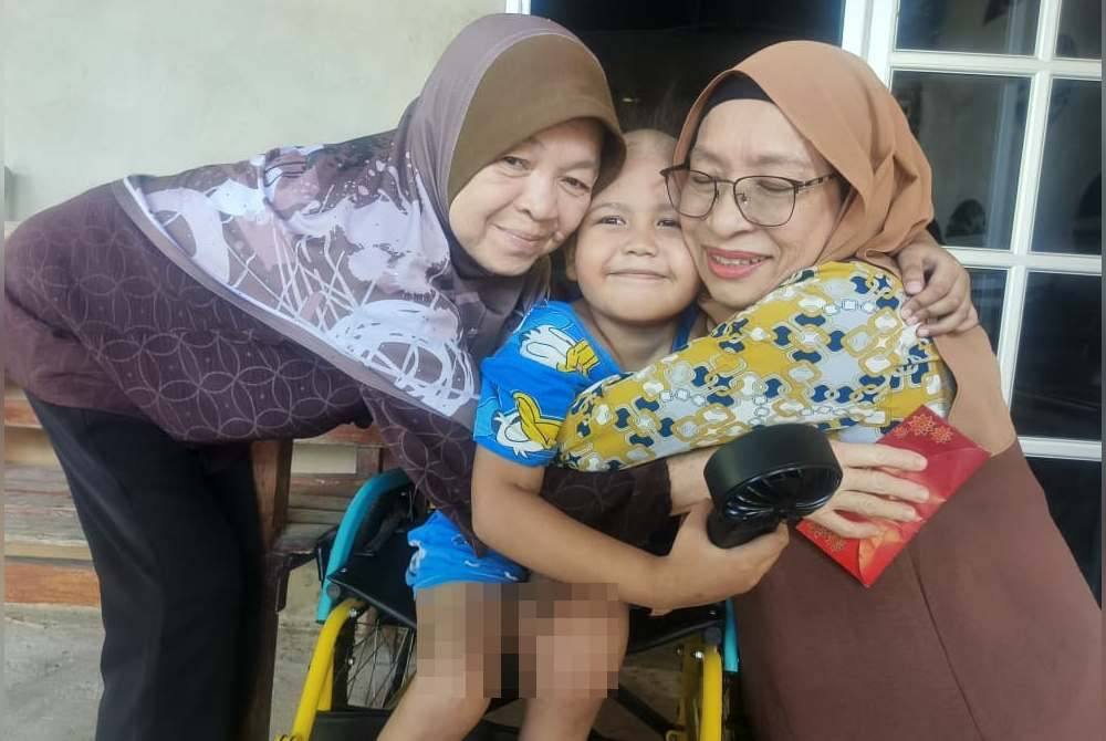Nur Fitriah Aliya Annisa being embraced by Zuraini (right) and Azlina at her home in Kampung Pengkalan Tok Putih, Jalan Tualak, Kuala Nerang on Wednesday.
