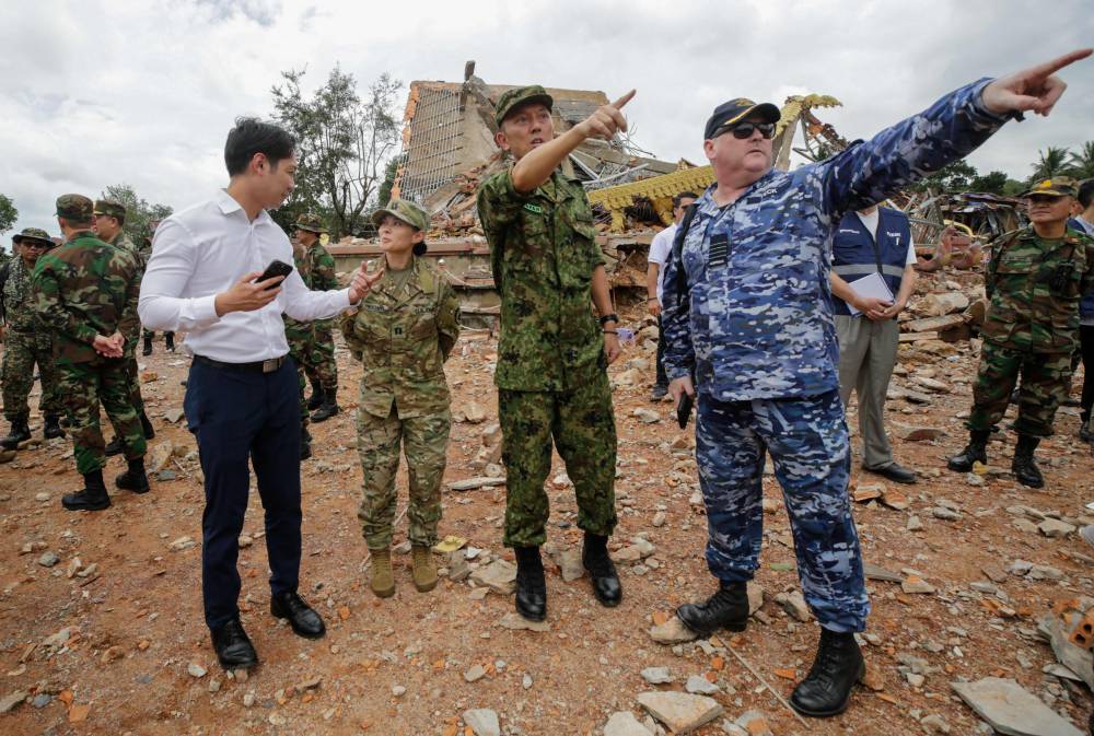 Military attaches and diplomats from 13 countries, including the United States (2nd L), Japan (C), and Australia (R) observe the implementation of the Cambodia–Thailand ceasefire agreement next to a destroyed building by the An Ses border checkpoint in Cambodia's Preah Vihear province on July 30, 2025. Thailand accused Cambodia on July 30 of a "flagrant violation" of a truce deal to end cross-border fighting, saying Cambodian troops launched an overnight attack on the frontier. (Photo by Chor Sokunthea / AFP)