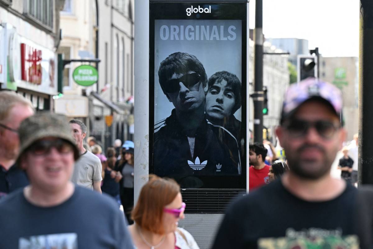 An advertisement showing British rock band Oasis is seen in the centre of Cardiff on July 4, 2025, ahead of the opening concert of their highly anticipated reunion tour nearly 16 years after last performing together. - (Photo by OLI SCARFF / AFP)