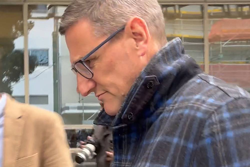This frame grab taken from AFPTV footage on Aug 4, 2025 shows New Zealand's former deputy police commissioner Jevon McSkimming leaving court after he was charged with possessing child sexual exploitation and bestiality material in Wellington. - (Photo by BEN STRANG / AFPTV / AFP)