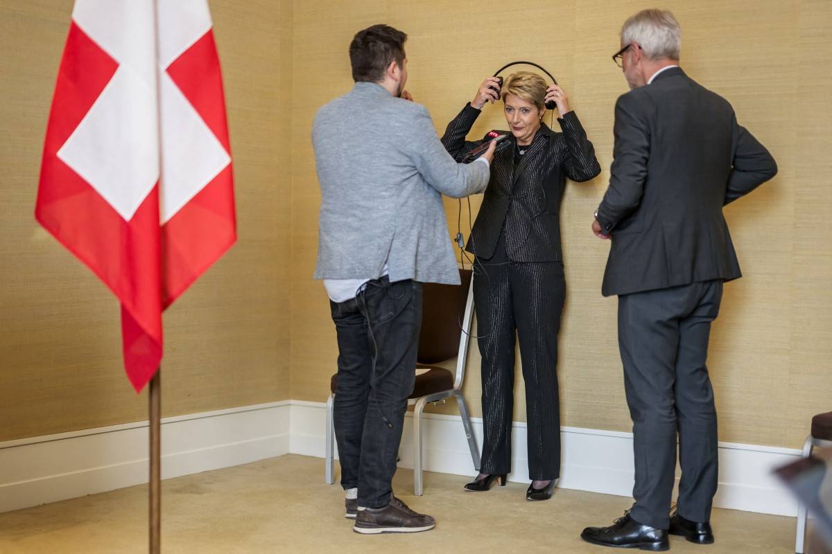 Switzerland's President Karin Keller-Sutter (C) puts on headphones as he prepares to deliver a speech after a meeting to discuss trade relations and tariffs, in Geneva, on May 9, 2025. Switzerland and the United States agreed to speed up talks on striking a deal on Washington's tariffs, the Swiss president said following a meeting with top US officials. (Photo by Fabrice COFFRINI / AFP)