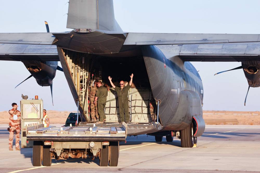 TOPSHOT - French military personnel load an aircraft with humanitarian aid in Jordan, before an airdropping operation over the Gaza Strip on August 2, 2025. (Photo by Ahmad GHARABLI / AFP)