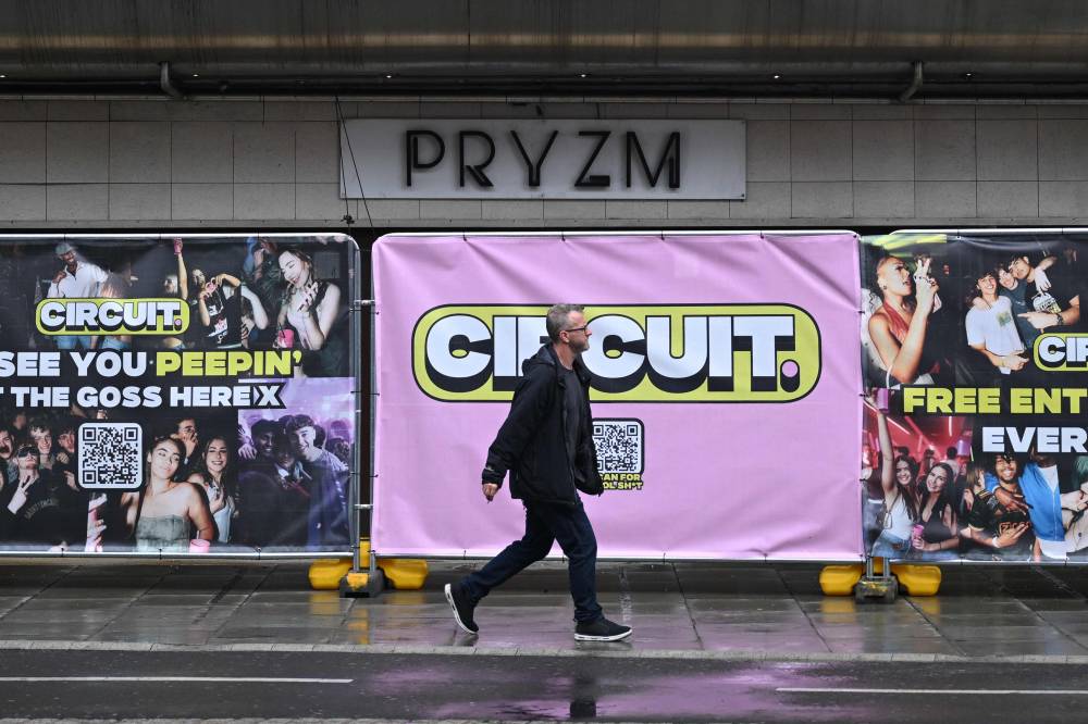 A man walks past the boarded up entrance to the closed-down PRYZM Kingston club in Kingston, west of London, on July 31. Photo by Justin Tallis/AFP